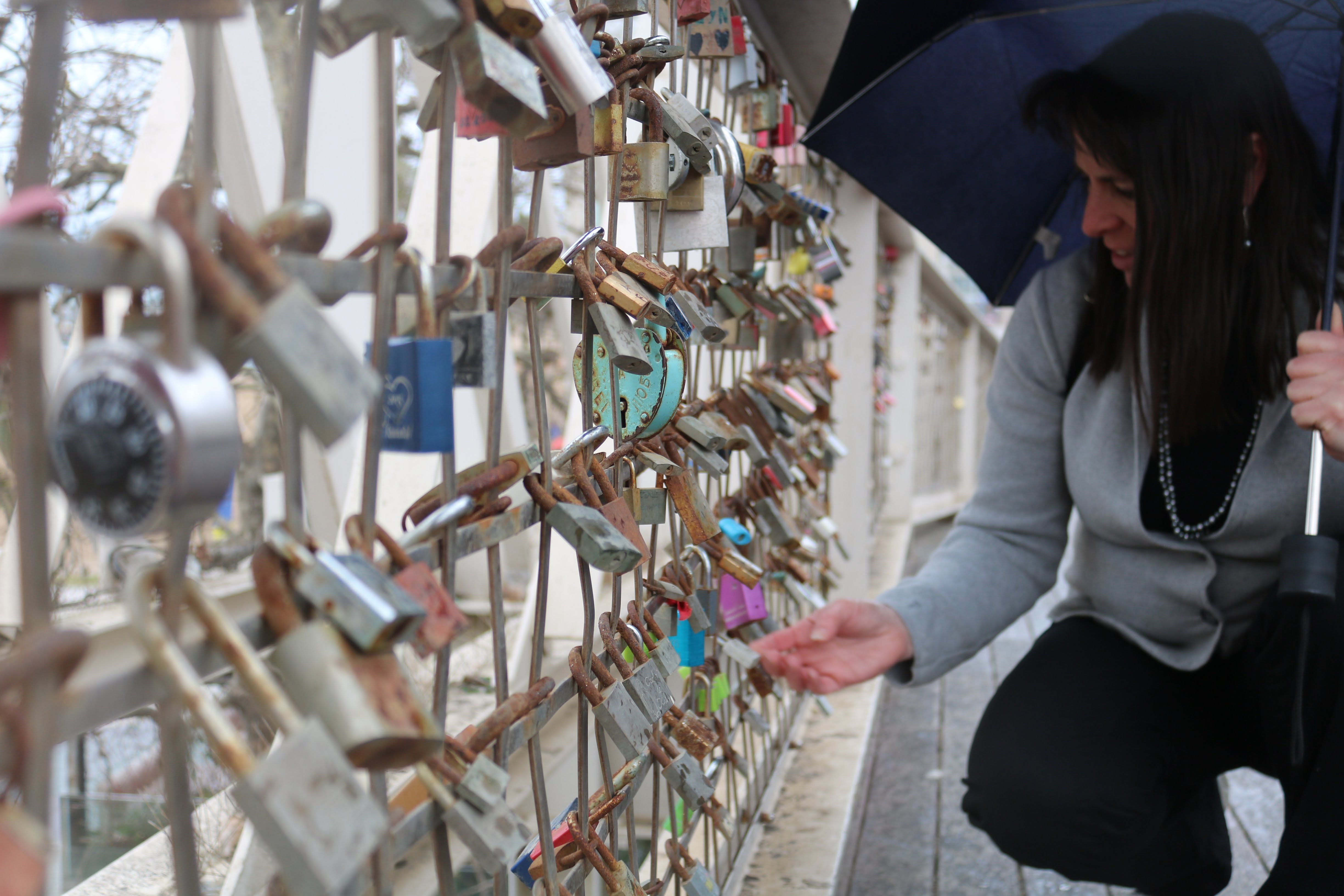 lady looking at locks on a fence